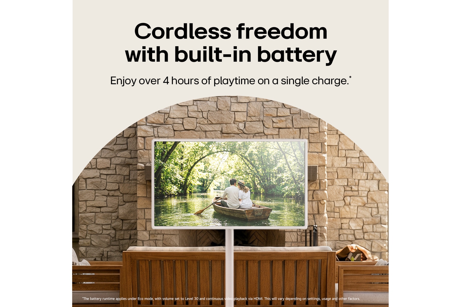 LG StanbyME 2 Max LX6 Movable Screen with a Built-in Battery stands among wooden furniture in a stone-walled courtyard, supporting over four hours of playback in one charge for flexible viewing without a power connection.