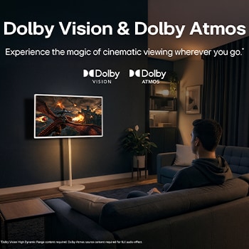 LG StanbyME 2 Max LX6 Movable Screen with Dolby Vision & Dolby Atmos shows a man watching a cinematic dragon battle in a dark room, where lifelike visuals and immersive sound create a theater-like experience at home.