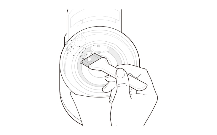 A person detaches the dust bin from the product and turns the product upside down to clean the dust between the Kompressor system using a cleaning brush. The person avoids pressing the Kompressor lever too hard to prevent damage to the working plate. Then, the product is turned over again, and the remaining dust is shaken out while pressing the Kompressor lever