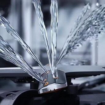Intense water streams from dishwasher blades in close-up.