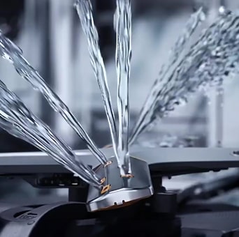 Intense water streams from dishwasher blades in close-up.