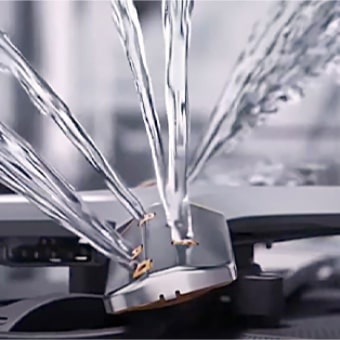 Intense water streams from dishwasher blades in close-up.