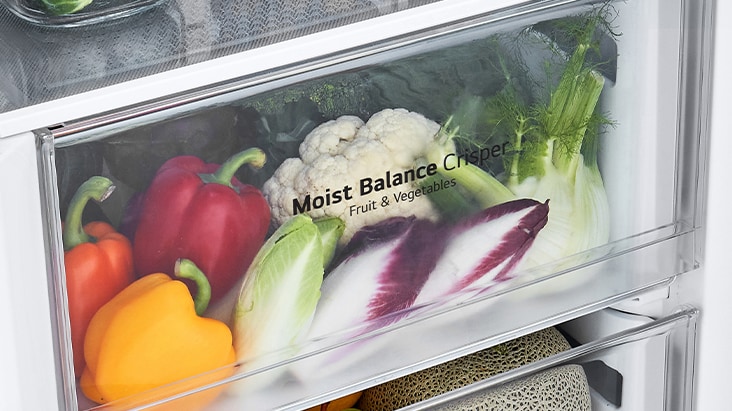 The bottom drawers of the fridge are filled with colorful fresh produce. An inset image magnifies the control lever to choose the optimal humidity level to keep produce fresh.	