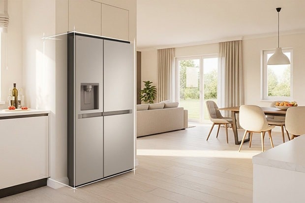 Bright beige-toned kitchen interior with a silver LG fridge freezer built into the left side. On the right, a dining table with flowers placed on top completes the scene.