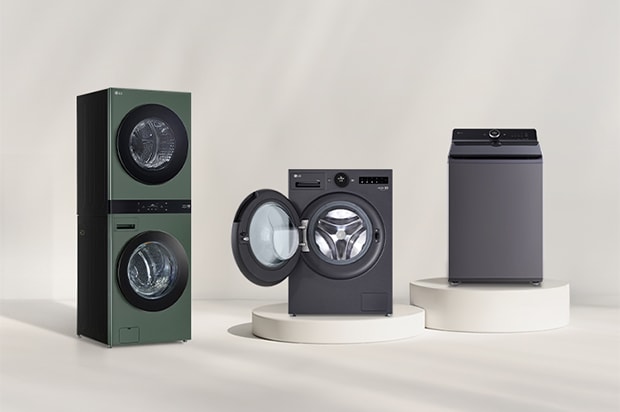 In front of the beige wall, there is the LG Wash Tower, front loading washer and top loading washer. On the right, you can see the forest view.	