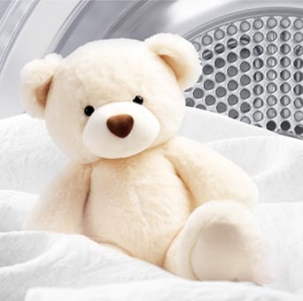 Image of a blanket and teddy bear inside a LG dryer