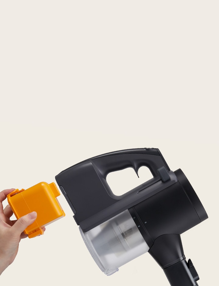 Hand with yellow battery approaching battery compartment