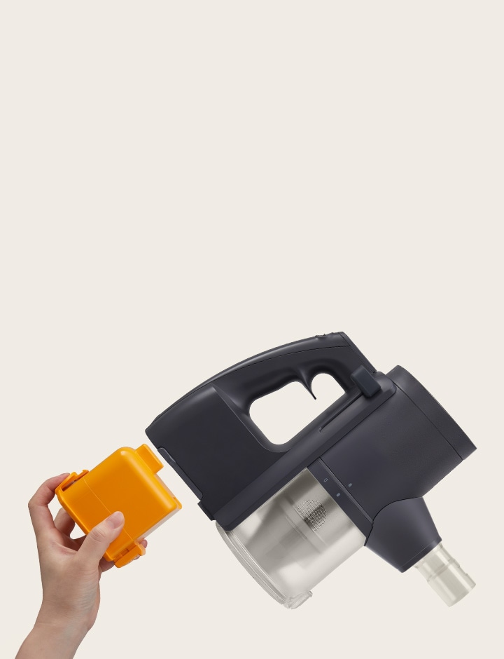 Hand with yellow battery approaching battery compartment