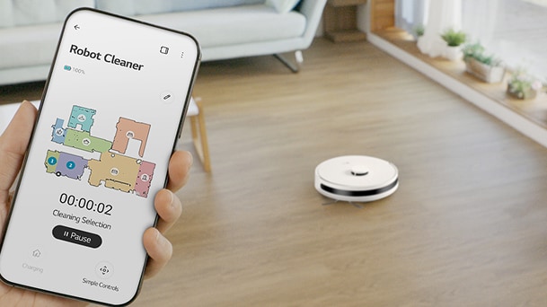 LG robot vacuum cleaner on wood floor with phone app showing Robot Cleaner map and cleaning timer.