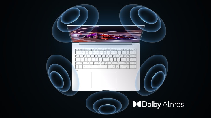 'The image shows a top-down view of a laptop with a vibrant, purple-themed graphic on the screen. Surrounding the laptop are dynamic sound wave visuals, indicating an immersive audio experience. The "Dolby Atmos" logo is displayed in the bottom right corner.