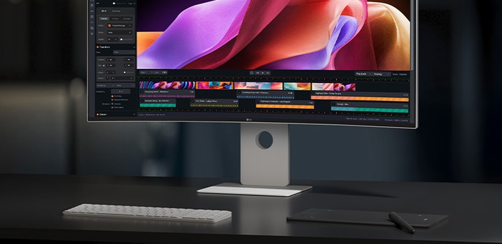 UltraFine™ stands on a desk along with keyboard and a pad. A video-creating program is on the screen.	