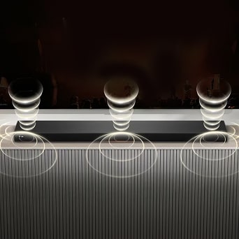 A soundbar emitting rich, immersive sound wave patterns from its top and bottom.