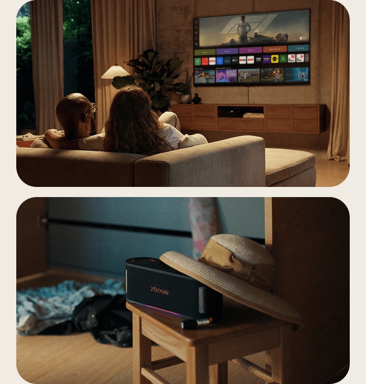 An LG xboom AI speaker resting on a side table, next to a couple relaxing on a sofa watching LG Channels on their LG AI TV.