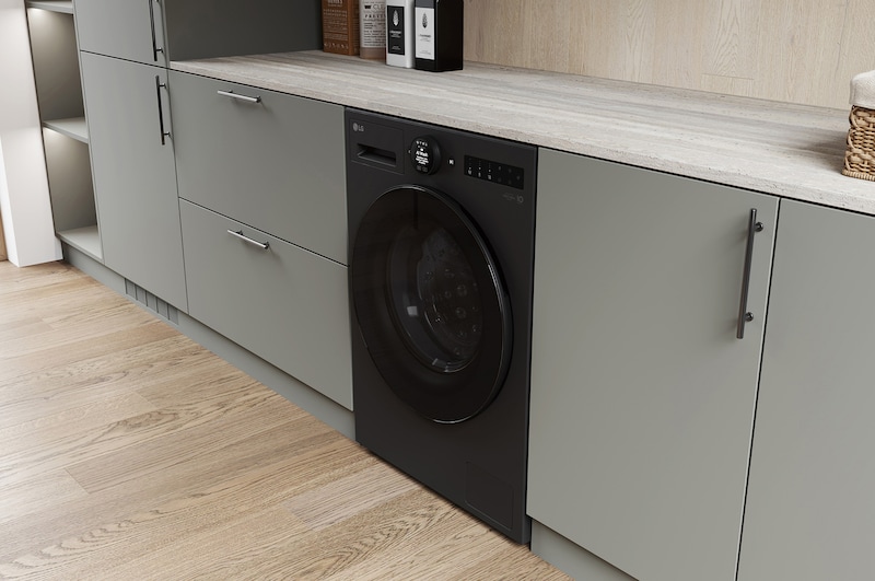 De matzwarte LG 11 kg wasmachine F4WX801YB, geïnstalleerd in een moderne keuken om het strakke, geïntegreerde ontwerp te benadrukken.