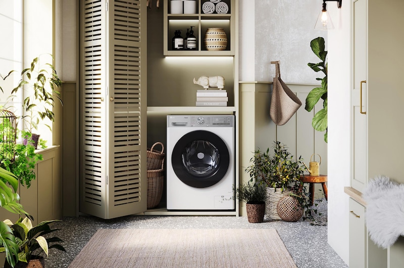 De witte LG 13 kg  wasmachine F4DR9537S2W met zijn strakke design, netjes geïnstalleerd onder het aanrecht van een moderne wasruimte.
