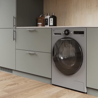 In de wasruimte staat een zilveren LG wasmachine naast een grijze lade, met wasmiddelen erop.
