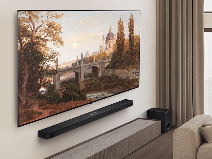 Woonkamer met een LG OLED TV en een LG Soundbar die op de wand is gemonteerd. Het perspectief is vanuit een hoek die het slanke frame van de tv tegen de muur laat zien. 