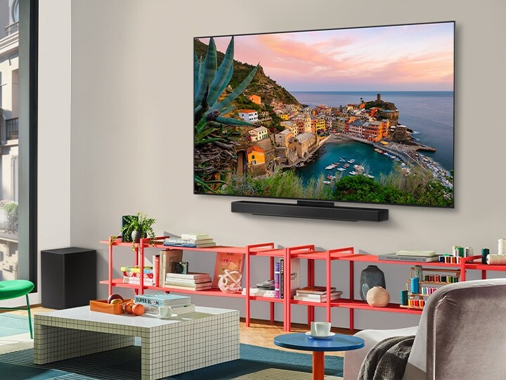 In een kleurrijke woonkamer hangt een LG OLED TV met Soundbar aan de muur. Het perspectief is vanuit een hoek die het ultradunne frame van de tv tegen de muur laat zien. 