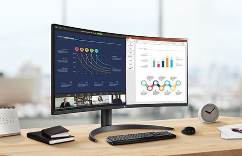 Er staat een UltraWide-monitor op het bureau, gepositioneerd in een hoek van 30 graden naar links. Het scherm is in tweeën gesplitst, waarbij op de linkerhelft een videoconferentie wordt uitgevoerd en op de rechterhelft aan een document wordt gewerkt.