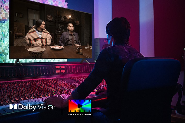 Een regisseur bij een bedieningspaneel terwijl deze de film ‘Killers of the Flower Moon’ bewerkt op een LG OLED TV. Linksonder staan het Dolby Vision-logo en FILMMAKER MODE-logo.