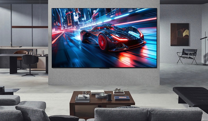 Woonkamer met een ultragrote LG TV aan de muur. Op het scherm is een racespel te zien. Door het formaat van het scherm voelt de inhoud veel meeslepender aan.