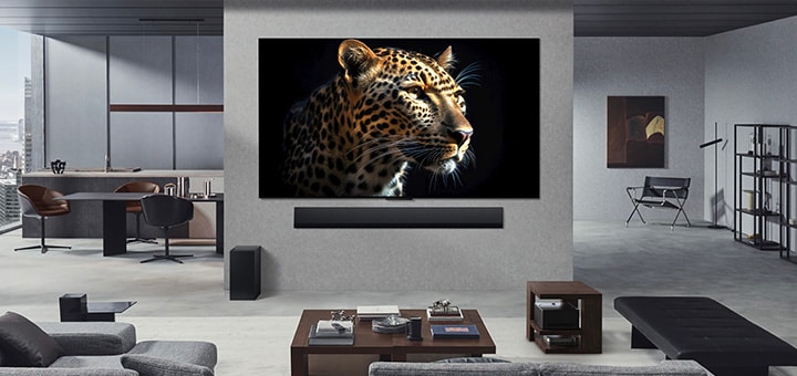 Een aan de wand gemonteerde LG OLED M5 TV en LG Soundbar in de woonkamer van een chic appartement. De Zero Connect Box verborgen onder een bijzettafeltje.