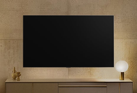Een wandgemonteerde LG TV lijkt te zijn uitgeschakeld, maar de Always Ready-functie is ingeschakeld. Deze geeft informatie weer en doorloopt daarna verschillende kunstwerken.