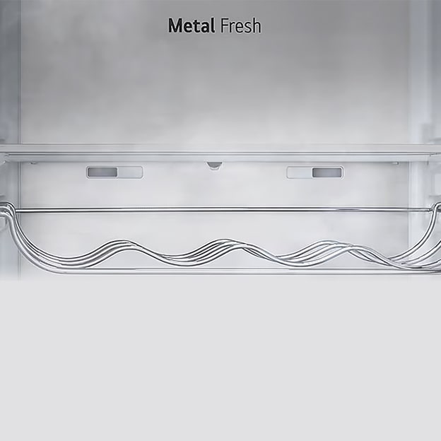 Close-up van het interieur van een koelkast met het label “Metal Fresh”, met een strakke metalen achterwand en een golvend metalen wijnrek onderaan.