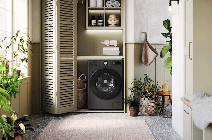 De witte LG 11 kg wasmachine F4WR7011SYB met zijn strakke design, netjes geïnstalleerd onder het aanrecht van een moderne wasruimte.