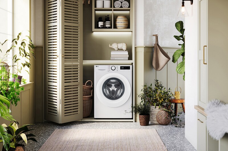 De witte LG 9kg wasmachine F4DR3096N3W met zijn strakke design, netjes geïnstalleerd onder het aanrecht van een moderne wasruimte.