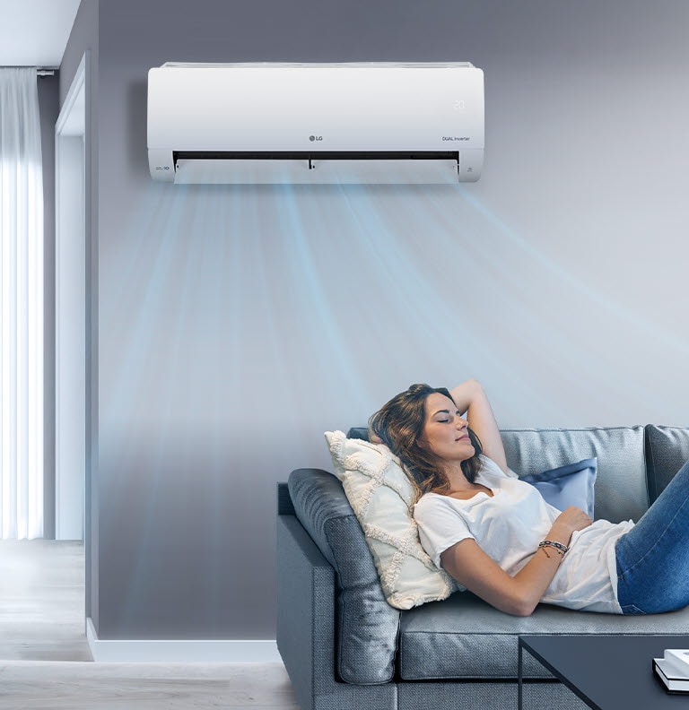 Een vrouw ligt op een bank in een woonkamer met boven haar aan de muur een LG-airconditioner. Blauwe luchtstromen staan op het beeld om aan te geven dat hij aan staat en de kamer koelt.