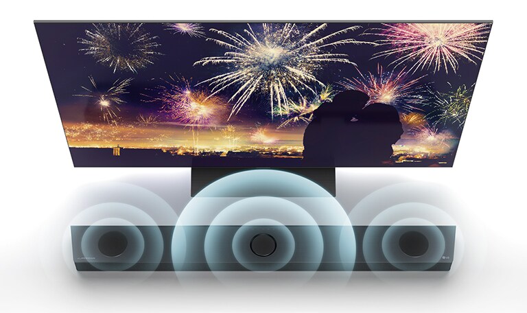 In vogelvluchtperspectief staat de LG TV op de vloer en de LG soundbar staat recht onder de tv in de oneindige ruimte. Op het scherm, een silhouet van een koppel op de achtergrond van vuurwerk. Soundwave-beelden komen uit de middelste, linker en rechter luidspreker bovenaan de soundbar.