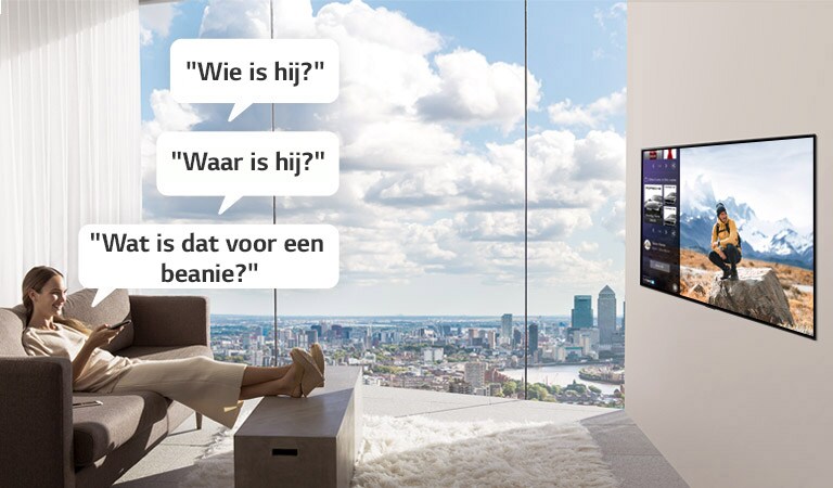 Een vrouw die naar de tv kijkt en vraagt: "Wie is hij?", "Waar is hij?", en "Welke beanie is dat?" 