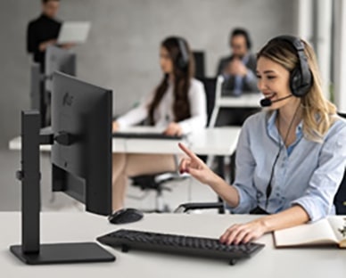 Een vrouw met een headset in een callcenter in gesprek met een klant.	
