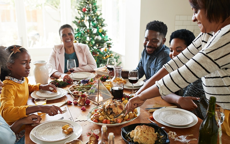 Une famille savoure son dîner avant de ranger ses restes de vacances dans le réfrigérateur.