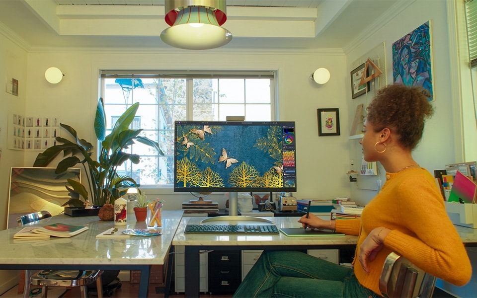Une femme utilise un moniteur propre dans son bureau à domicile