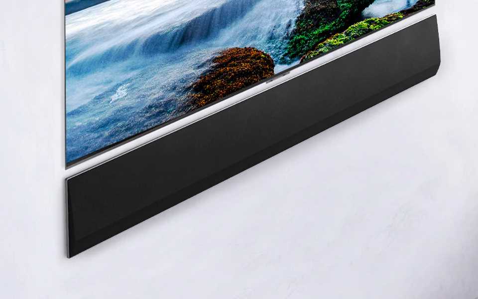 The LG Soundbar GX placed flush on the wall underneath an LG TV.