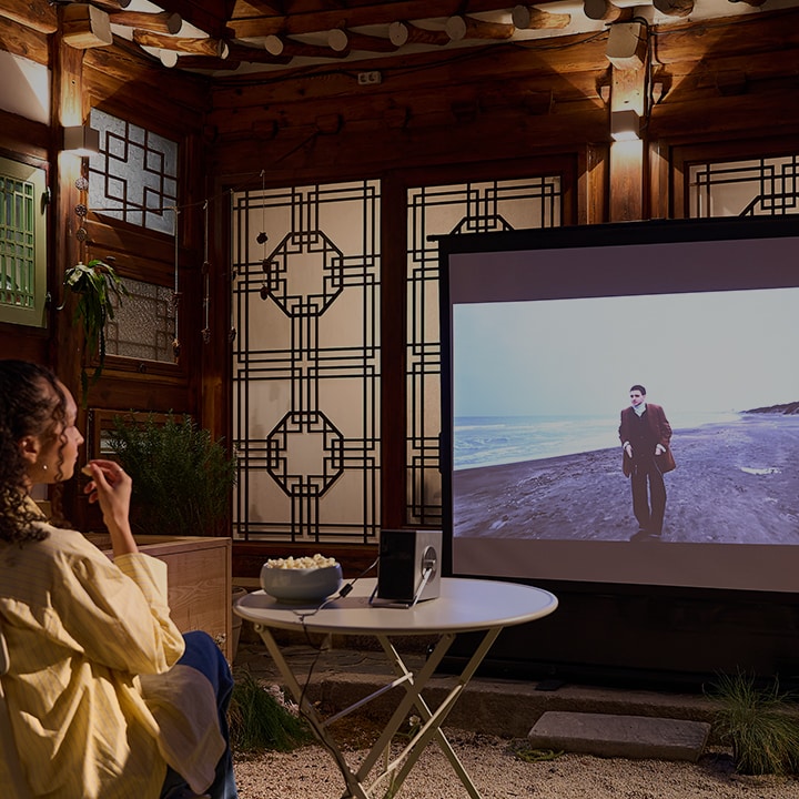 La vidéo montre un client dans une maison d'hôtes hanok regardant un film, écoutant de la musique et savourant son petit-déjeuner avec des appareils LG.