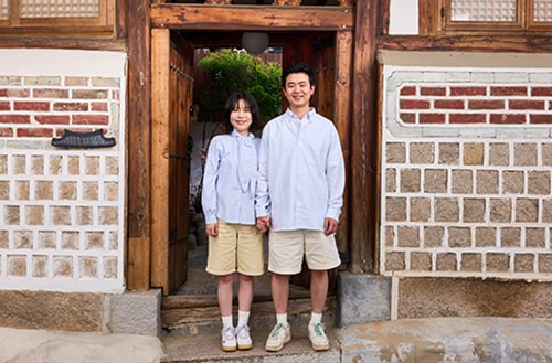 De gastheren staan voor het Hanok Guesthouse.