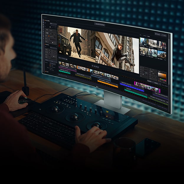 Um homem trabalhando em edição de vídeo usando software de edição em um monitor.