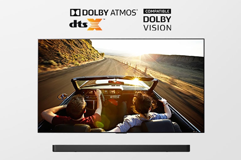 Tela exibindo estrada ao pôr do sol em um conversível, com logos Dolby Atmos e DTS:X acima.