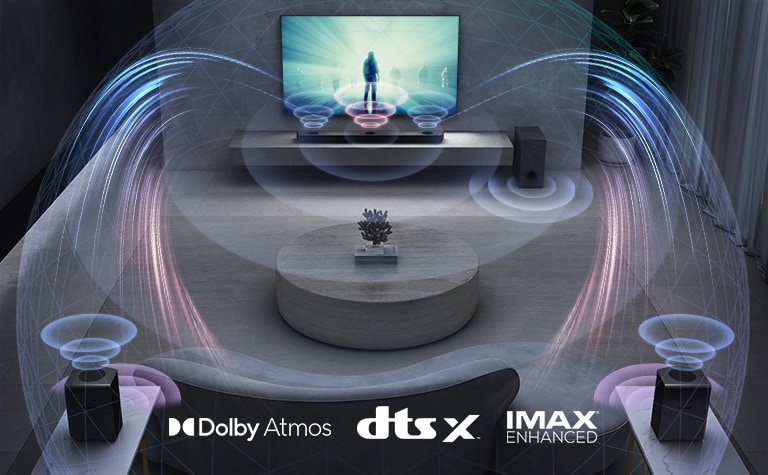 A TV LG está na parede de uma sala de estar. Um filme está sendo exibido na tela da TV. A Sound Bar LG está logo abaixo da TV sobre um rack cinza, com um subwoofer ao lado. Um conjunto com duas caixas de som traseiras está na parte de trás da sala de estar. Gráficos de efeito sonoro emanam de cada uma das caixas de som. Logotipos Dolby Atmos e DTS:X são exibidos na parte central inferior da imagem.