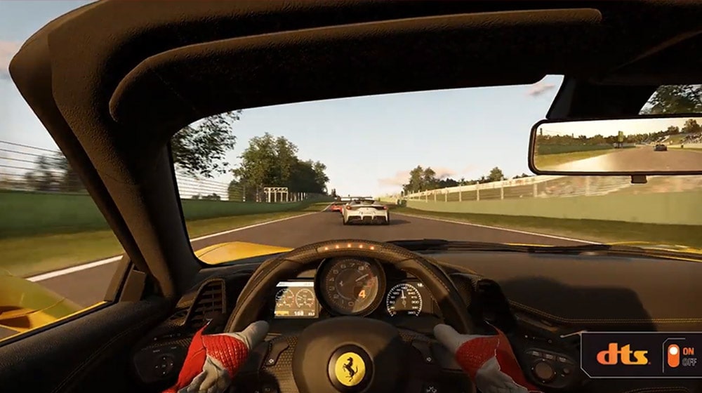 Link para um vídeo DTS do Project Cars 2. A captura de tela traz a vista pela perspectiva de um piloto guiando um carro de corrida numa pista, e o logotipo DTS está no canto inferior direito da imagem.