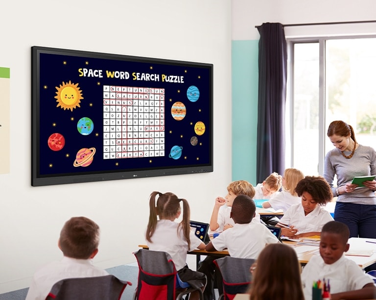A aula está sendo ministrada na sala de aula, e o conteúdo da aula exibido no LG CreateBoard na parede está sendo compartilhado nos tablets dos alunos.