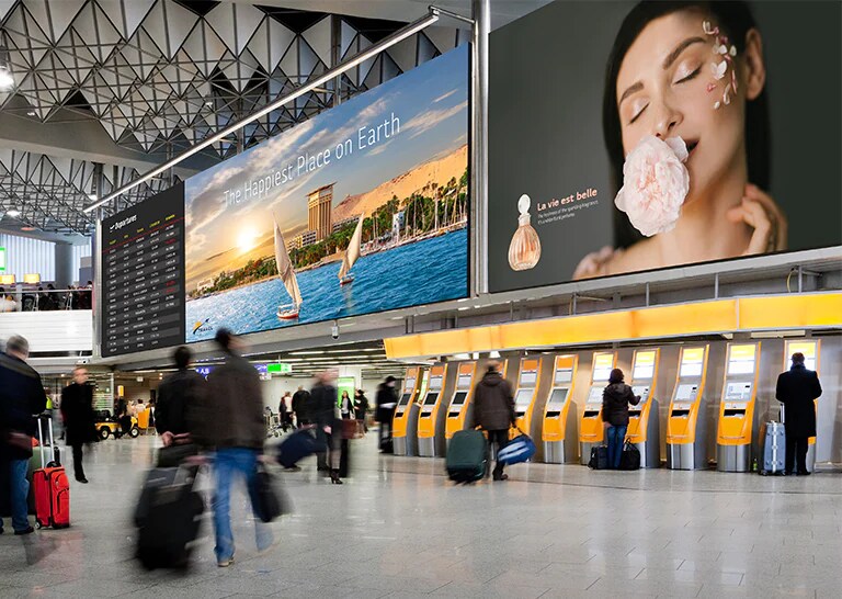 Grandes telas de LED dentro de um aeroporto mostram os horários de partida dos passageiros e anúncios.