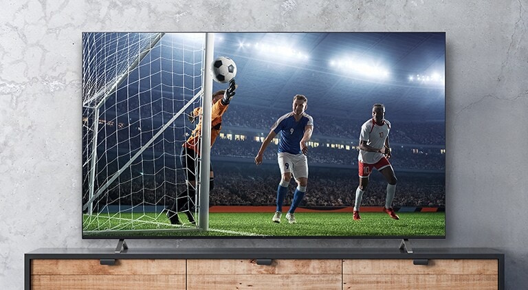 A cena do jogo de futebol mostrada na tela da TV parece real.
