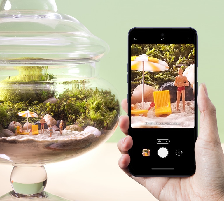 Smartphone fotografando miniaturas em um aquário.