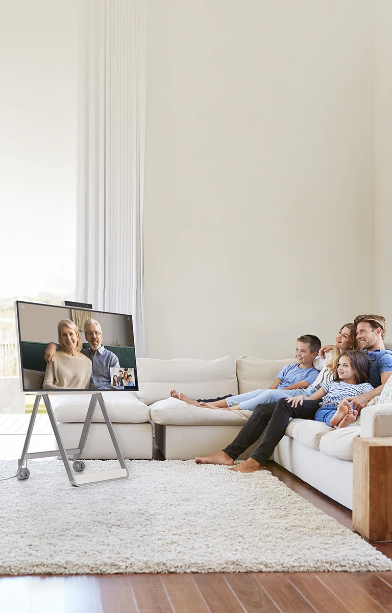 Uma família está na sala de estar, fazendo uma videochamada por meio do produto