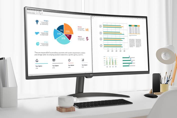 Na mesa, há um monitor inteligente, exibindo um documento de home office sendo trabalhado. À esquerda do monitor, há um copo com alça e, à direita, um telefone celular, um porta-lápis e um suporte.