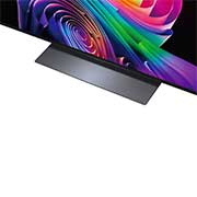 A LG OLED evo AI C6 está instalada na parede de uma sala de estar elegante, apresentando um design ultrafino com bordas estreitas, e exibe na tela uma paisagem urbana à beira do rio ao pôr do sol.